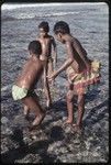 Fishing: children play with net in shallow lagoon near Wawela village, boys wear leaf coverings, girl (r) wears short fiber skit