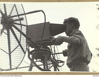 PORT MORESBY, NEW GUINEA. 1943-12-16. AN OPERATOR WORKING ON THE (SEARCHLIGHT CONTROL) SITE TESTING EQUIPMENT AT THE HEAVY ANTI-AIRCRAFT GUN SITE H.8, ROYAL AUSTRALIAN ARTILLERY