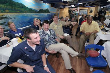 ESPN (Entertainment and Sports Programming Network) commentators and former NFL (National Football League) players Mike Golic (pointing), Mark Schlereth (left), Green Bay Packer fullback William Henderson and US Navy (USN) Sailors watch the 2005 NFL Super Bowl in the galley onboard the Arleigh Burke Class Destroyer USS RUSSELL (DDG 59). Golic, Schlereth and Henderson were invited for a visit to the RUSSELL to watch the Super Bowl with the ship's crew, have lunch and tour the ship