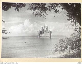 MOILA POINT, BOUGAINVILLE. 1945-09-27. THE HITATI MARU, A JAPANESE MERCHANT SHIP KNOCKED OUT BY ALLIED BOMBING AND RUN ASHORE. THE SURRENDER PARTY FROM HEADQUARTERS 2 CORPS IS MAKING ARRANGEMENTS ..