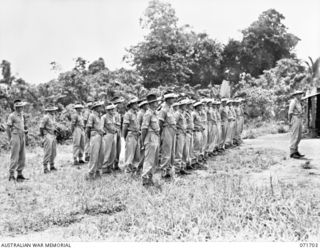 LAE, NEW GUINEA, 1944-03-25. MEMBERS OF THE 3RD DIVISION PROVOST COMPANY ATTACHED TO HEADQUARTERS LAE BASE SUB-AREA UNDER VX108085 LIEUTENANT R. J. SCOBIE (EXTREME RIGHT), DURING A FULL PARADE ..