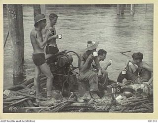 BOUGAINVILLE. 1945-04-23. 15 FIELD COMPANY, ROYAL AUSTRALIAN ENGINEERS, SAPPERS TAKE TIME OFF FOR A BREW DURING THE CONSTRUCTION OF A NEW AUSTPANEL BRIDGE OVER THE PURIATA RIVER. THIS BRIDGE WILL ..