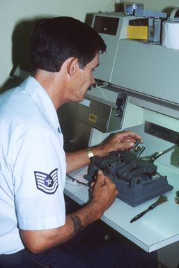 Technical Sergeant Lowell Mitchell, 137th Combat Support Squadron, Oklahoma Air National Guard, services a 16 mm motion picture film splicer in the audiovisual services department