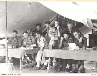 MADANG, NEW GUINEA. 1944-08-15. PERSONNEL WORKING IN THE ADMINISTRATION AND TRANSPORT OFFICE OF THE 165TH GENERAL TRANSPORT COMPANY. IDENTIFIED PERSONNEL ARE:- NX107368 CAPTAIN J.H. MCCLAFFERTY, ..