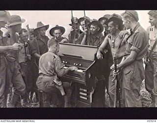 KAIAPIT, NEW GUINEA. 1943-09-26. IN THE OUTDOORS MEN OF THE 2/6TH AUSTRALIAN INDEPENDENT COMPANY AND THE 2/27TH AUSTRALIAN INFANTRY BATTALION ENJOY AN IMPROMPTU ORGAN RECITAL GIVEN BY SX3962 STAFF ..