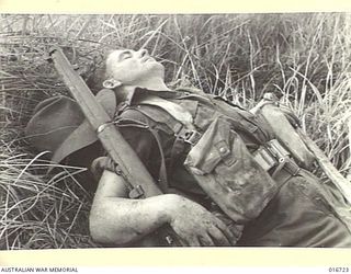 1944-03-23. NEW GUINEA. TIRED - AND FAR FROM HOME. FLAT ON HIS BACK FOR A SHORT REST IS SX5932 PRIVATE LAURIE LESLY DANIELS, 2/10TH BATTALION, OF HINDMARSH, SOUTH AUSTRALIA. HE'S ONE OF A GROUP OF ..