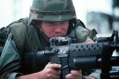 A Marine armed with an M16A2 rifle equipped with an M203 grenade launcher stands watch on the roof of the United States Embassy. Marines of the 22nd Marine Expeditionary Unit (22nd MEU), deployed aboard the amphibious assault ship USS SAIPAN (LHA 2), were sent to augment security at the embassy as part of Operation SHARP EDGE