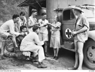 1943-07-26. NEW GUINEA. FIVE HUNDRED MEALS AT A TIME AT A HOSPITAL PICNIC, OR UNLOADING BOATS OF WOUNDED ALLIED TROOPS, HAVE BEEN CATERED FOR BY THIS RED CROSS MOBILE CANTEEN. WITH THE SOLDIERS WHO ..