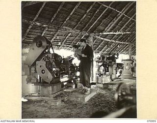 LABU, NEW GUINEA. 1944-03-10. LATHES AND OTHER MACHINERY USED AT THE 1ST WATERCRAFT WORKSHOPS, AUSTRALIAN ELECTRICAL AND MECHANICAL ENGINEERS FOR REFITTING SHIPS ENGINES. IDENTIFIED PERSONNEL ARE:- ..