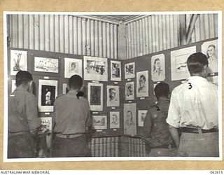 PORT MORESBY, PAPUA, NEW GUINEA. 1943-12-23. PERSONNEL EXAMINING THE PRIZE WINNING WATER COLOURS AT THE ARTS AND CRAFTS EXHIBITION STAGED BY THE AUSTRALIAN ARMY EDUCATION SERVICE, HEADQUARTERS, ..