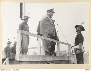 HERBERTON, QUEENSLAND. 1945-03-03. MAJOR GENERAL G.F. WOOTTEN, GENERAL OFFICER COMMANDING 9 DIVISION, (5), PRESENTING TROPHIES TO OFFICERS OF THE 24 INFANTRY BRIGADE REPRESENTING UNITS IN A PARADE ..