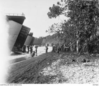 FINSCHHAFEN, NEW GUINEA, 1943-09-22. TROOPS OF THE FINSCHHAFEN FORCE UNLOADING STORES FROM LSTS (LANDING SHIP, TANK) AT THE BEACH HEAD