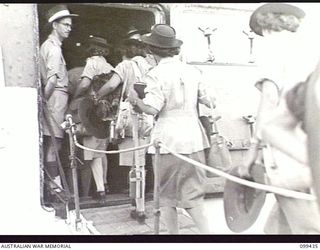 MILFORD HAVEN, NEW GUINEA, 1945-12-14. MEMBERS OF THE AUSTRALIAN ARMY MEDICAL WOMEN'S SERVICE MOVING ABOARD THE AUSTRALIAN TROOPSHIP SS MANUNDA