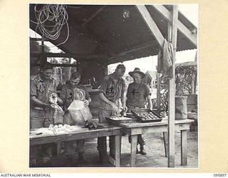 WIRUI BEACH, WEWAK, NEW GUINEA. 1945-09-04. MEMBERS OF 2/11 INFANTRY BATTALION MAKING DEHYDRATED POTATO RISSOLES. IDENTIFIED PERSONNEL ARE:- PRIVATE M.I. ROBERTSON (1); PRIVATE D.E. HAGAN (2); ..