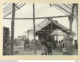 HOSKINS, NEW BRITAIN. 1944-10-10. NEW BRITAIN NATIVES STACKING STORES IN THE AUSTRALIAN ARMY SERVICE CORPS DEPOT AT THE 36TH INFANTRY BATTALION BEACHHEADS