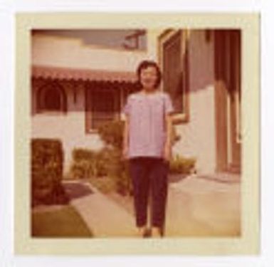 Betty Takamori standing in front of house