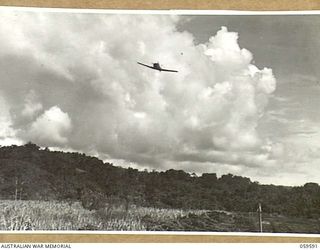 FINSCHHAFEN, NEW GUINEA, 1943-10-28. A WIRRAWAY AIRCRAFT OF NO. 4 SQUADRON (ARMY COOPERATION) RAAF PREPARING TO LAND AT THE BASE AERODROME AFTER A SUPPLY DROPPING RUN OVER THE AREA NEAR KATIKA, ..