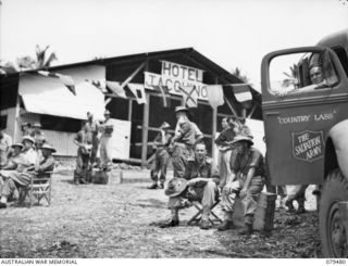 JACQUINOT BAY, NEW BRITAIN. 1945-03-11. SPECTATORS AND BOOKMAKERS OUTSIDE THE HOTEL JACQUINOT, THE WET CANTEEN SECTION OF THE ARMY ORDNANCE CORPS BULK STORE DURING THE AQUATIC CARNIVAL OF THE NEW ..