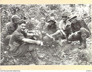 1943-08-09. NEW GUINEA. ALLIED SOLDIERS ON THEIR WAY TO THE FIGHTING NEAR MUBO STOP FOR A CUP OF TEA ON THE ROUGH JUNGLE TRACK AT MAT MAT. (NEGATIVE BY G. SHORT)