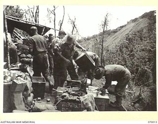 SHAGGY RIDGE, NEW GUINEA. 1944-01-10. CUT INTO THE SIDE OF THE "PIMPLE" ON SHAGGY RIDGE THIS KITCHEN IS SERVING "A" COMPANY 2/9TH INFANTRY BATTALION. IN THE BACKGROUND IS THE SOUTH EAST END OF THE ..