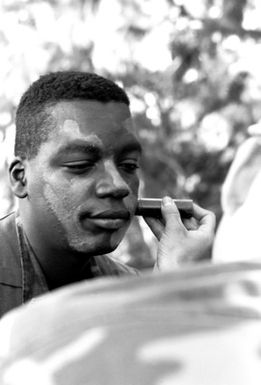 Photographer, SSGT Bradway applies camouflage grease paint to his face as he prepares for combat awareness field training, being given to photographers and illustrators to prepare them for combat situations