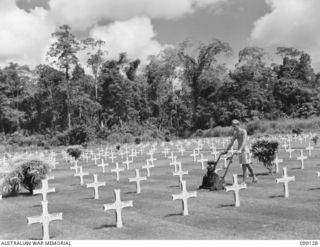 BUNA-GONA AREA, NEW GUINEA. 1945-10-16. SERGEANT R. TOWNSEND, AUSTRALIAN WAR GRAVES MAINTENANCE UNIT, MOWING THE LAWN AT THE SOPUTA WAR CEMETERY. ALTHOUGH NOW BECOMING AN ISOLATED SPOT BEHIND BUNA ..