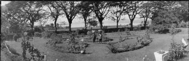 Two women carrying loads on their heads in the Chinnery's front garden, Malaguna Road, Rabaul, New Guinea, 1937 / Sarah Chinnery