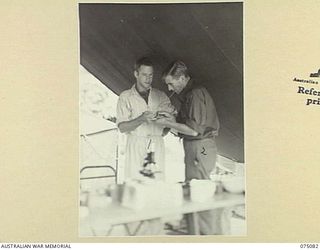 SOUTH ALEXISHAFEN, NEW GUINEA. 1944-08-08. VX148353 PRIVATE D.H. CRANSTON, MEDICAL ORDERLY (2) TAKING A BLOOD SAMPLE FROM NX176263 PRIVATE W.R. MCGOWAN, 35TH INFANTRY BATTALION (1) IN THE PATHOLOGY ..