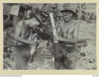 BOIKEN AREA, AITAPE-WEWAK SECTOR. 1945-04-28. SERGEANT S.J.A. SHIELDS (1); AND SERGEANT C.W. MANSON (2), MEMBERS OF 2/1 TANK ATTACK REGIMENT, PREPARING AMMUNITION FOR A 75MM PACK HOWITZER