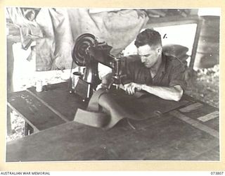 LAE, NEW GUINEA. 1944-06-09. QX42115 CRAFTSMAN E D PRATT MACHINING FABRIC IN THE TEXTILE WORKSHOP AT THE 2/7TH ADVANCED WORKSHOP