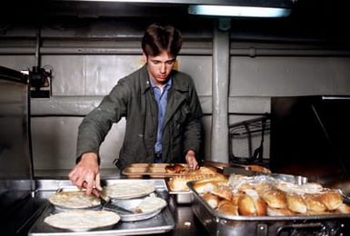 A crewman selects food while in the mess line aboard the amphibious assault ship USS GUAM (LPH 9). The ship is participating in operations off the coast of Lebanon