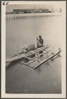 Man in a catamaran with Rabaul wharf in background, New Britain Island, Papua New Guinea, approximately 1916