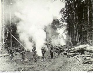 WAU - LAE ROAD, NEW GUINEA. 1944-03-10. AUSTRALIAN NEW GUINEA ADMINISTRATIVE UNIT NATIVES CLEARING A STRETCH OF JUNGLE 85 MILES FROM WAU