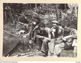 BOUGAINVILLE, 1945-07-12. TROOPS OF A COMPANY, 42 INFANTRY BATTALION, 29 INFANTRY BRIGADE ENJOYING A HOT MEAL IN THE COMPANY PERIMETER AFTER A STRENUOUS PATROL THROUGH THE JUNGLE. IDENTIFIED ..