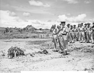 BOMANA WAR CEMETERY, PAPUA, NEW GUINEA. 1943-12-29. COMRADES PAYING THEIR LAST RESPECTS TO PENDIL A. RAYNER, AN AUSTRALIAN WAR CORRESPONDENT WHO WAS KILLED IN AN AIRCRAFT CRASH AT THE CONCLUSION OF ..