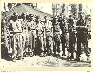 MOTUPINA POINT AREA, BOUGAINVILLE ISLAND. 1945-01-20. VX88167 MAJOR F.S.I. POWELL, COMMANDING, NO.5 BATTERY, 2ND FIELD REGIMENT (1), OUTSIDE THE UNIT COMMAND POST WITH HIS OFFICERS. IDENTIFIED ..