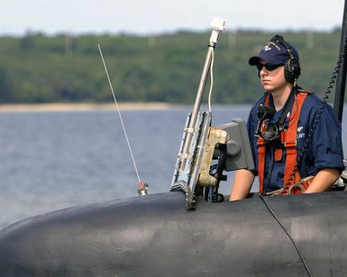 A phone talker, part of the navigation detail team of the LOS ANGELES class Attack Submarine USS SALT LAKE CITY (SSN 716), stands his watch as the submarine glides past Orote Point for a short port visit to Guam. The fast attack submarine has one nuclear reactor and measures at 360 feet long. The SALT LAKE CITY is on deployment and homeported out of San Diego, California