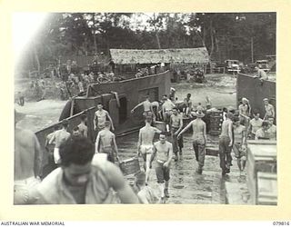 TOKO, BOUGAINVILLE, SOLOMON ISLANDS. 1945-03-20. TROOPS OF THE 2ND FIELD REGIMENT, ROYAL AUSTRALIAN ARTILLERY UNLOAD BOXES OF AMMUNITION FROM THE REAR OF AN AMERICAN LCT (LANDING CRAFT TANK)