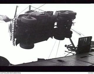 MILNE BAY, NEW GUINEA. 1943-06-30. 2/3RD AUSTRALIAN DOCKS OPERATING COMPANY, ROYAL AUSTRALIAN ENGINEERS, LIFTING A HEAVY AMERICAN TRUCK ONTO THE LIBERTY SHIP "MERIDETH"