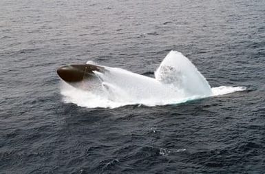 An aerial view of the LOS ANGELES CLASS Attack Submarine USS COLUMBUS (SSN 762) conducting an emergency surfacing drill, during a training exercise, off the coast of Oahu, Hawaii