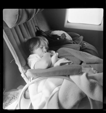 Young child Jennifer Gray, a passenger, sleeping on Qantas Catalina flying boat service from Suva, Fiji, to Sydney, Australia