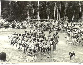 KAMALGAMAN ANCHORAGE, JACQUINOT BAY, NEW BRITAIN. 1944-12-31. NEW GUINEA NATIVES DANCING AND SINGING DURING A SING-SING IN THE AUSTRALIAN NEW GUINEA ADMINISTRATIVE UNIT NATIVE COMPOUND