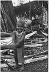 Pig festival, pig sacrifice, Tsembaga: smiling child stands by women in ancestral shrine