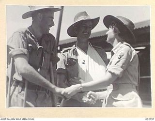 LAE, NEW GUINEA. 1945-06-09. ASSISTANT SUPERINTENDENT R.A. PARROTT, RED CROSS SOCIETY (3), FAREWELLS SERGEANT V.H. SMITH (1) AND LANCE CORPORAL F.W. WALKER (2), FORMER PATIENTS AT 2/7 GENERAL ..