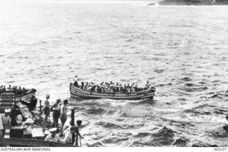 NAURU, PACIFIC ISLANDS. 1942-02. CIVILIANS EVACUATED FROM NAURU AND OCEAN ISLAND BY THE FREE FRENCH DESTROYER LE TRIOMPHANT APPROACH THE SHIP IN BOATS. (NAVAL HISTORICAL COLLECTION)