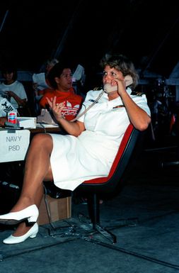 A Navy lieutenant talks on the telephone while working in a temporary evacuation center during Operation Fiery Vigil. The center was set up to process military dependents who were evacuated from the Philippines after volcanic ash from the eruption of Mount Pinatubo disrupted operations at Clark Air Base and Naval Station, Subic Bay.