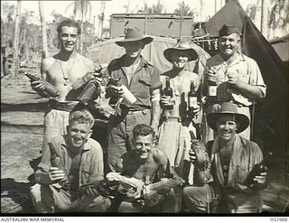 AITAPE, NORTH EAST NEW GUINEA. 1944-05-02. GROUP PORTRAIT OF RAAF PERSONNEL WHO LANDED WITH THE AMERICAN ASSAULT FORCES HOLDING BOTTLES OF JAPANESE LIQUOR INCLUDING JAPANESE CHAMPAGNE, LAGER, WINE ..