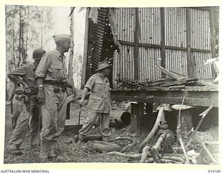 1943-01-14. LIEUT. GENERAL R.L. EICHELBERGER AND GENERAL SIR THOMAS BLAMEY INSPECT A BUILDING AT BUNA MISSION, THE SCENE OF SOME OF THE BLOODIEST FIGHTING OF THE PAPUAN CAMPAIGN. NOTE THE ..