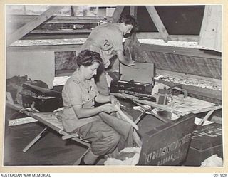 LAE, NEW GUINEA. 1945-05-07. PRIVATE M. JENKINSON (1), AND PRIVATE M. MATHIESEN (2), UNPACKING IN THEIR NEW QUARTERS AT THE NEWLY CONSTRUCTED AUSTRALIAN WOMEN'S ARMY SERVICE WHO TRAVELLED ON THE MV ..