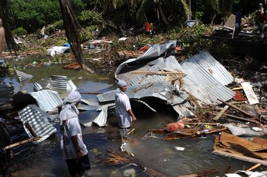 Earthquake ^ Tsunami - Leone, American Samoa, October 2, 2009 -- Two residents of the village of Leone walk through waist high water removing debris that was caused by the recent tsunami. The tsunami spread debris throughout the village of Leone.